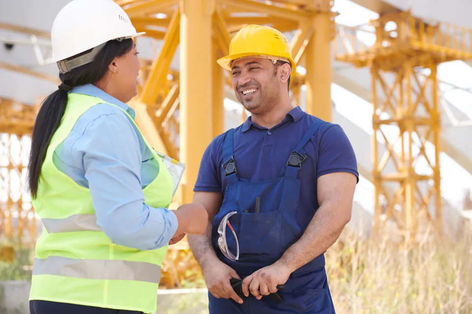 Planerin und Bauleiter im Gespräch auf der Baustelle